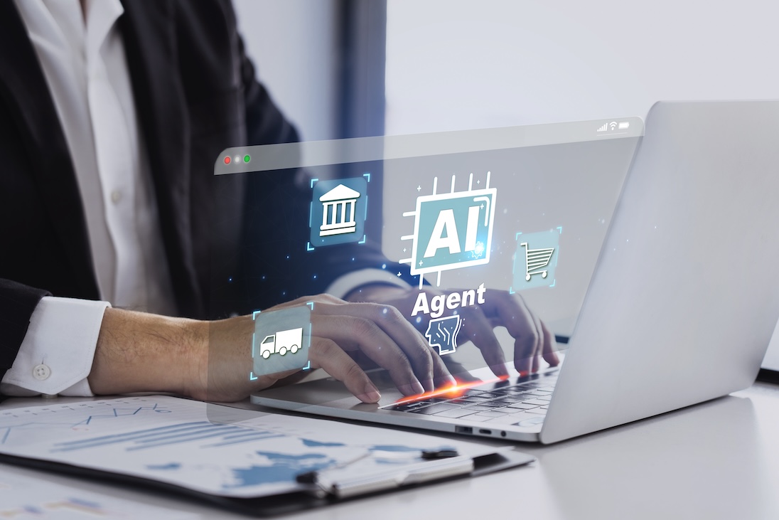 Twee handen van een man, die op laptop typt en daaruit komen symbolen voor AI, home en transport